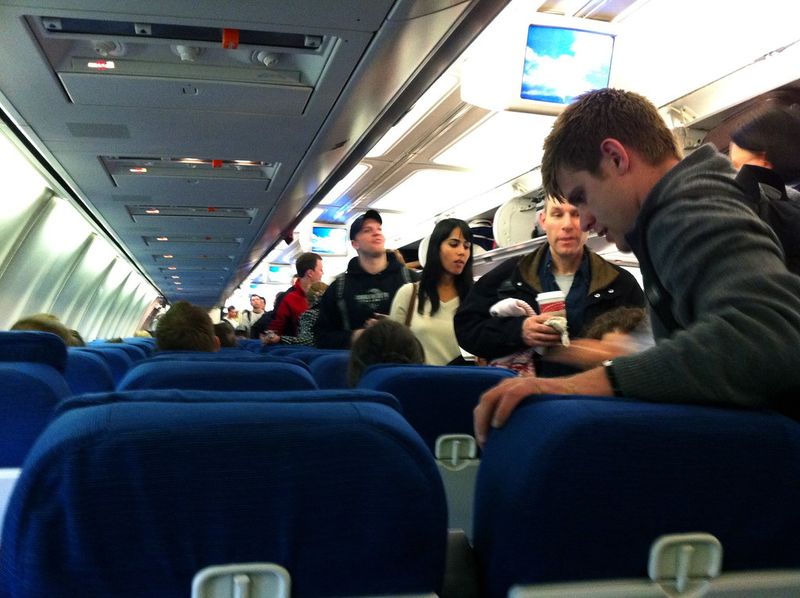 Standing in the aisle while others are still boarding