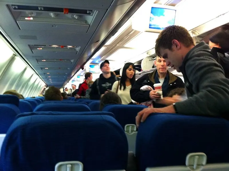 Standing in the aisle while others are still boarding