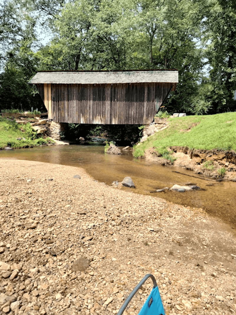 A Swimming Hole With an Old Bridge Watching
