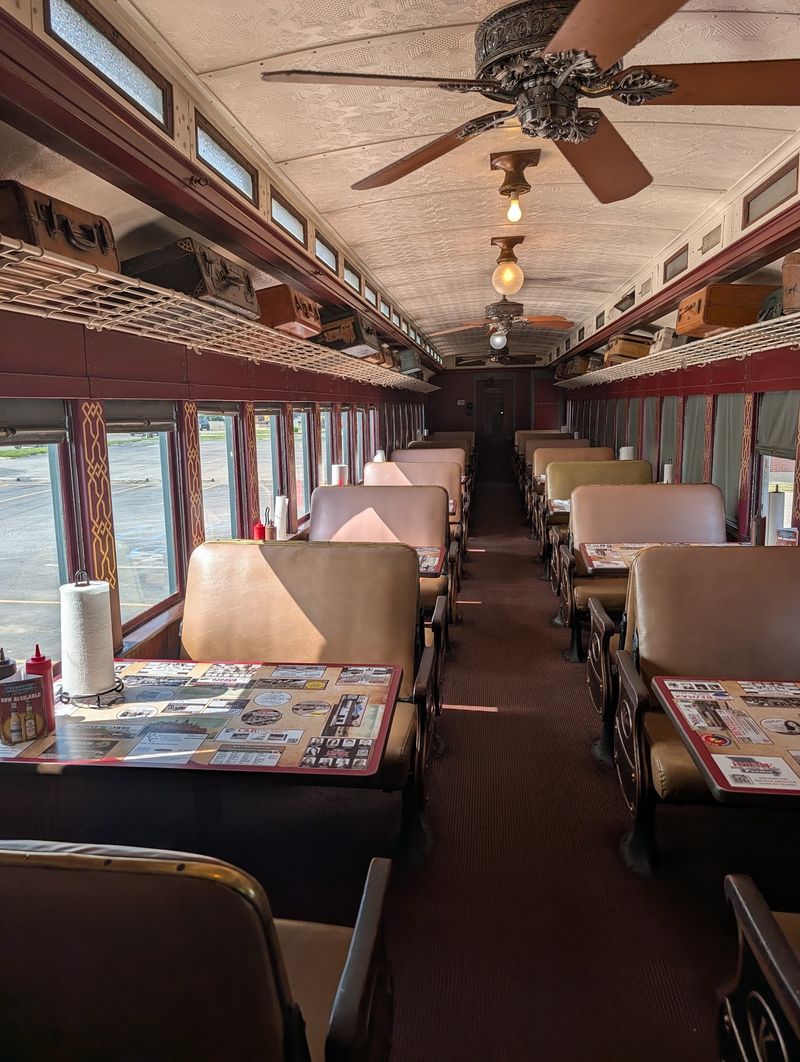 Booths, Brass Racks, And Suitcases Overhead